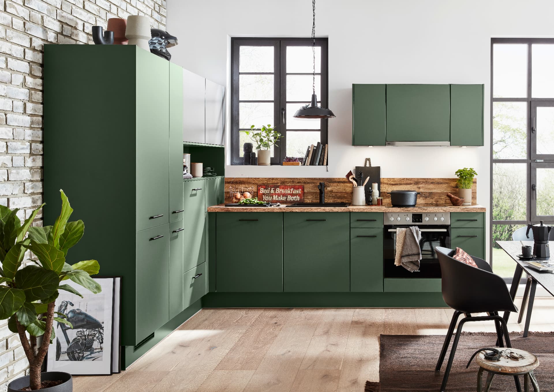 Impuls IP 1200 kitchen in matt forest green with black bar handles and a rustic oak worktop