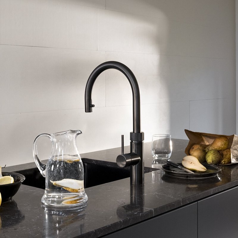 Quooker Flex Round boiling water tap in gunmetal pouring sparkling water